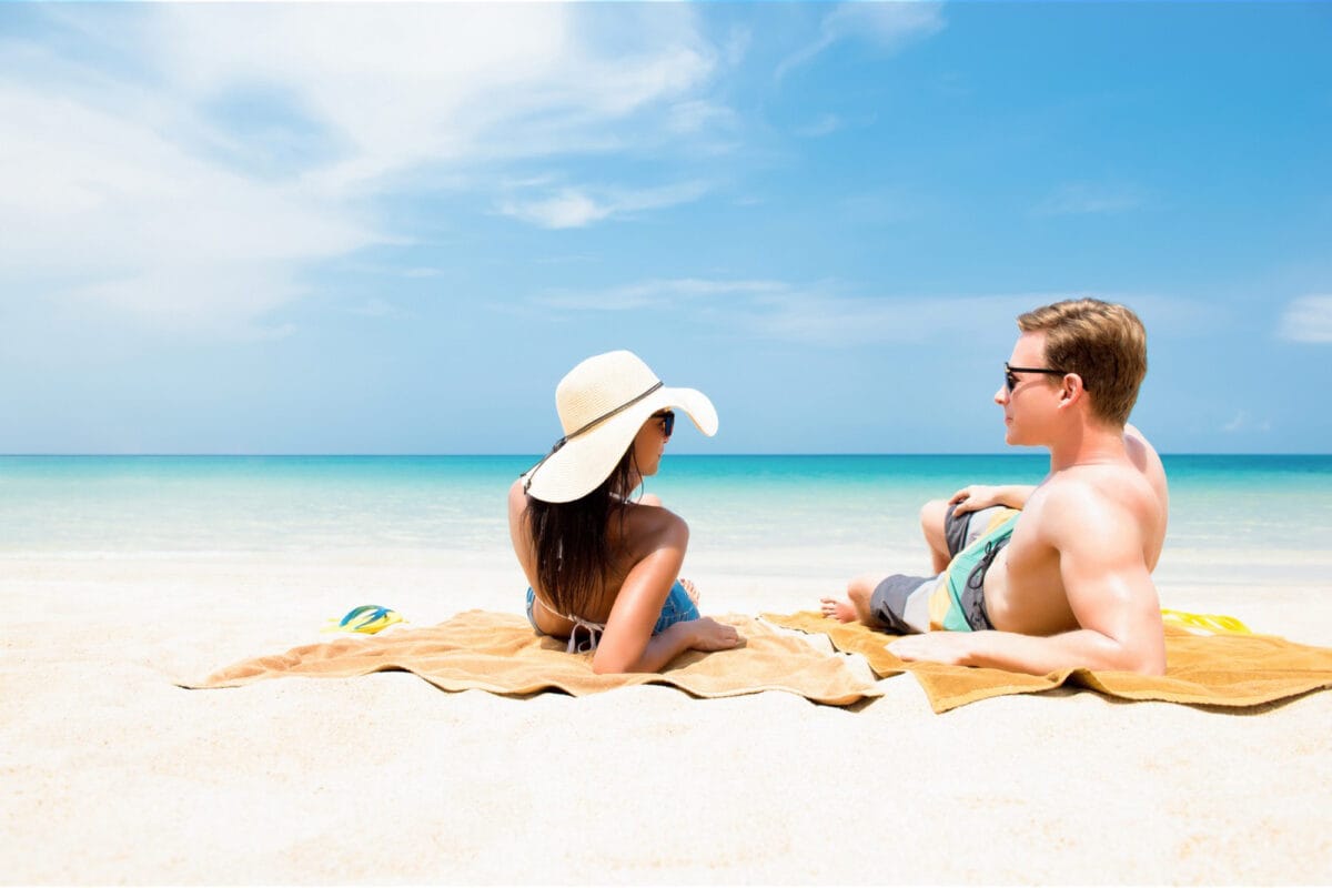 Couple lying on white sand beach in summer