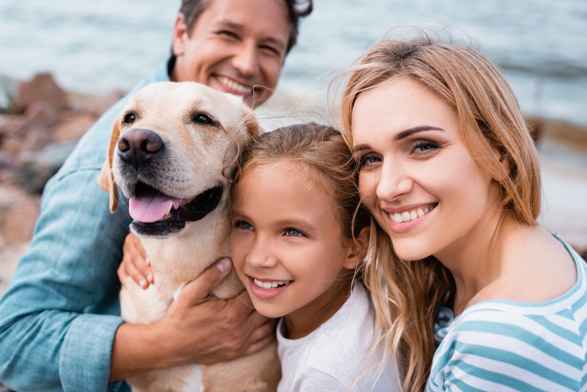 Family and golden retriever on seaside.